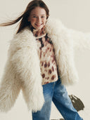 Момиче с пухкаво бяло яке и леопардова блуза от зимната колекция на Gulliver