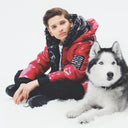 Момче в червено зимно яке Gulliver седи до хъски на снежен фон